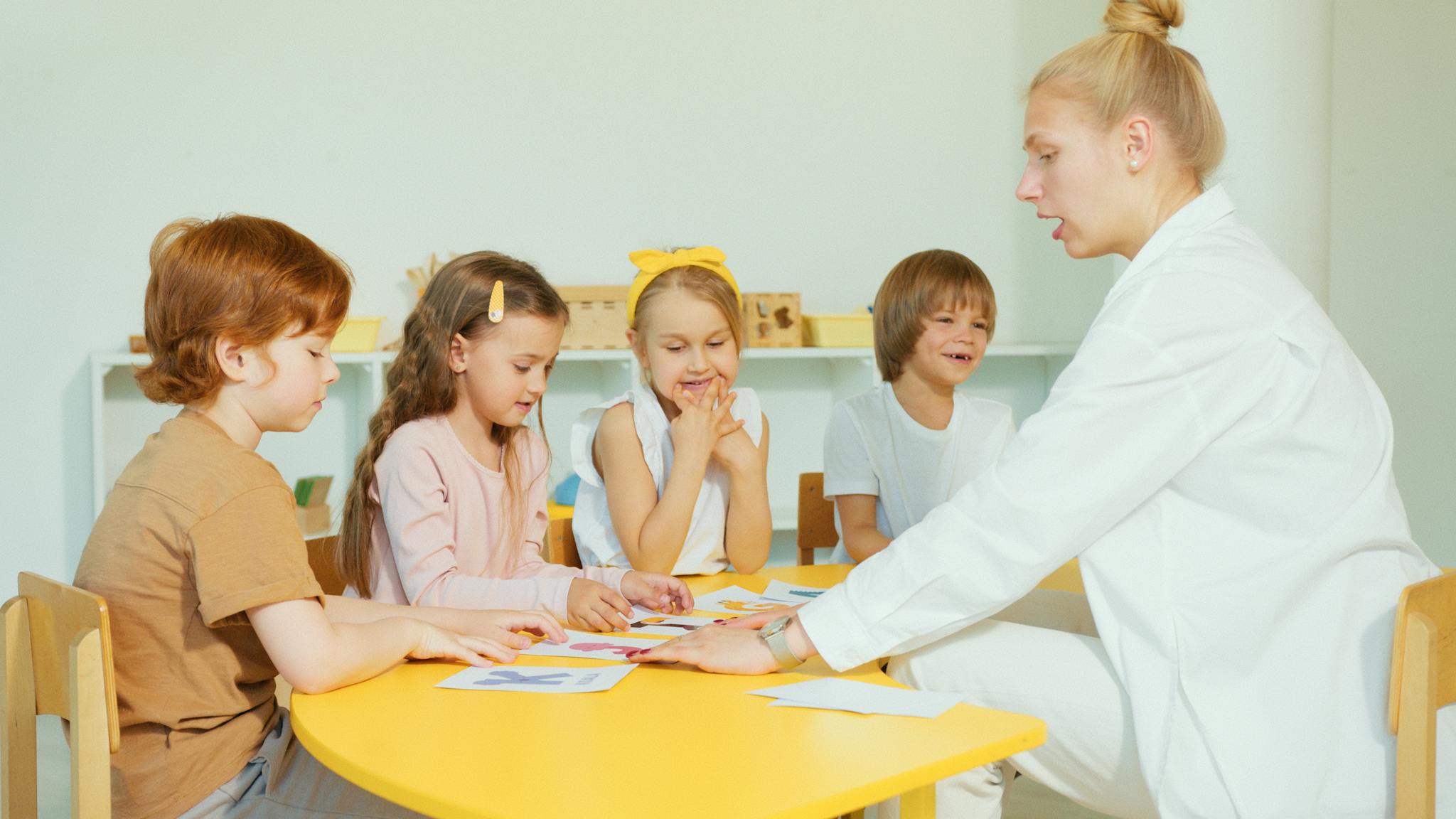 Preschool children learning with a teacher during a fun classroom activity.